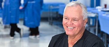Dr. Brent Norris, smiling in an operating room like setting
