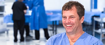 Dr. Matthew Gardner, smiling in scrubs in an operating room like setting