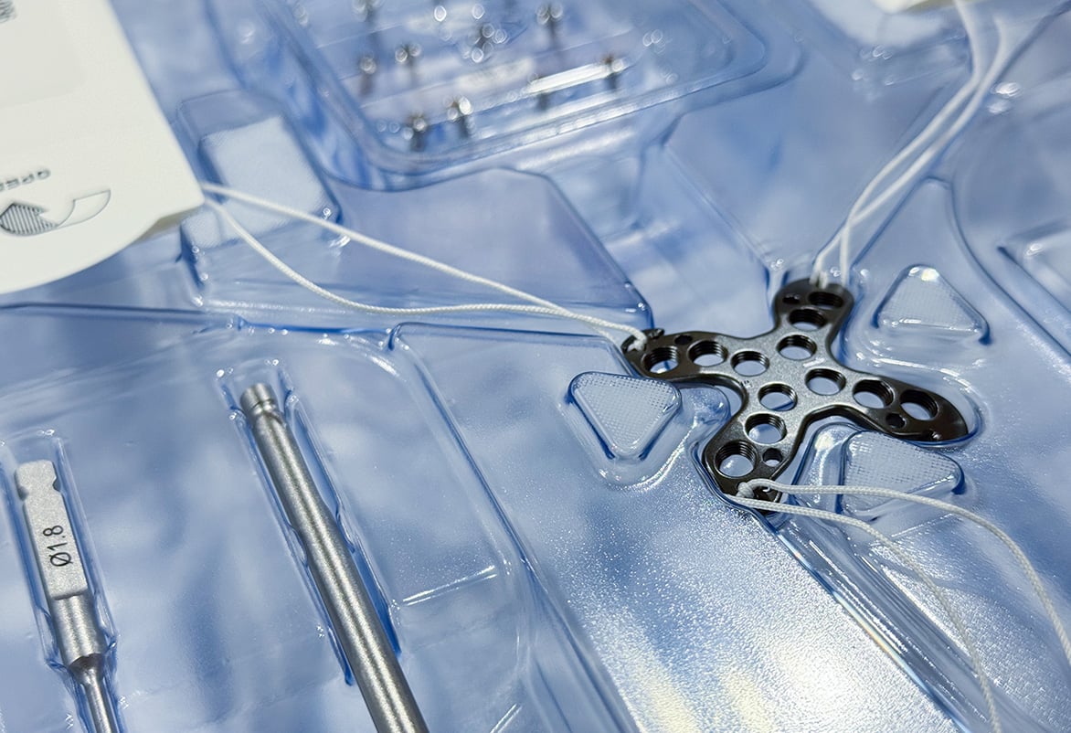 Close up of The Summit™ Patella Plate laid inside the kit packaging