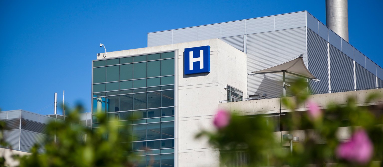 Exterior of a modern hospital building marked with an H sign