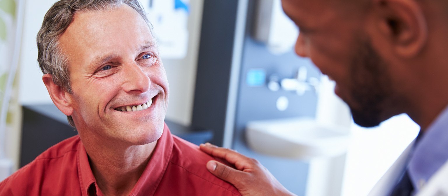 Smiling patient talking with a clinician during an exam