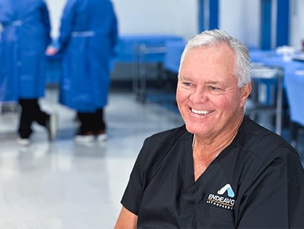 Dr. Brent Norris smiling in an operating room setting